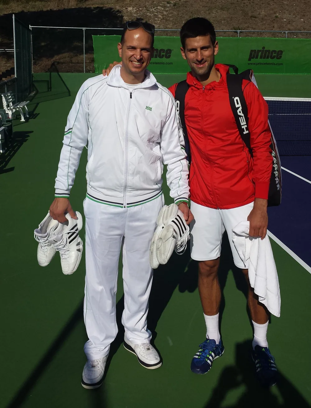 Novak Djokovic reviewing his custom orthotics with Tamir Kfir on a tennis court