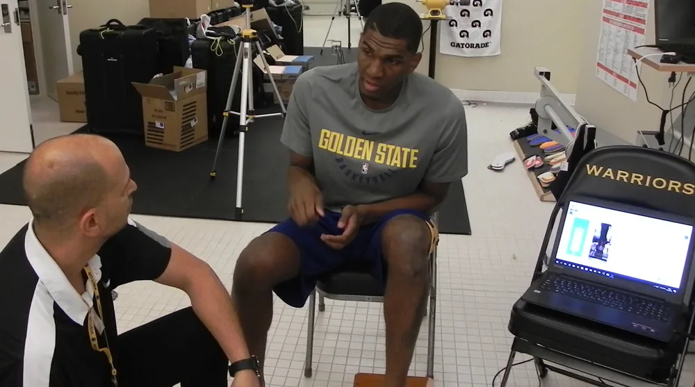 Tamir Kfir fitting custom orthotics with an NBA champion at the Golden State Warriors facility